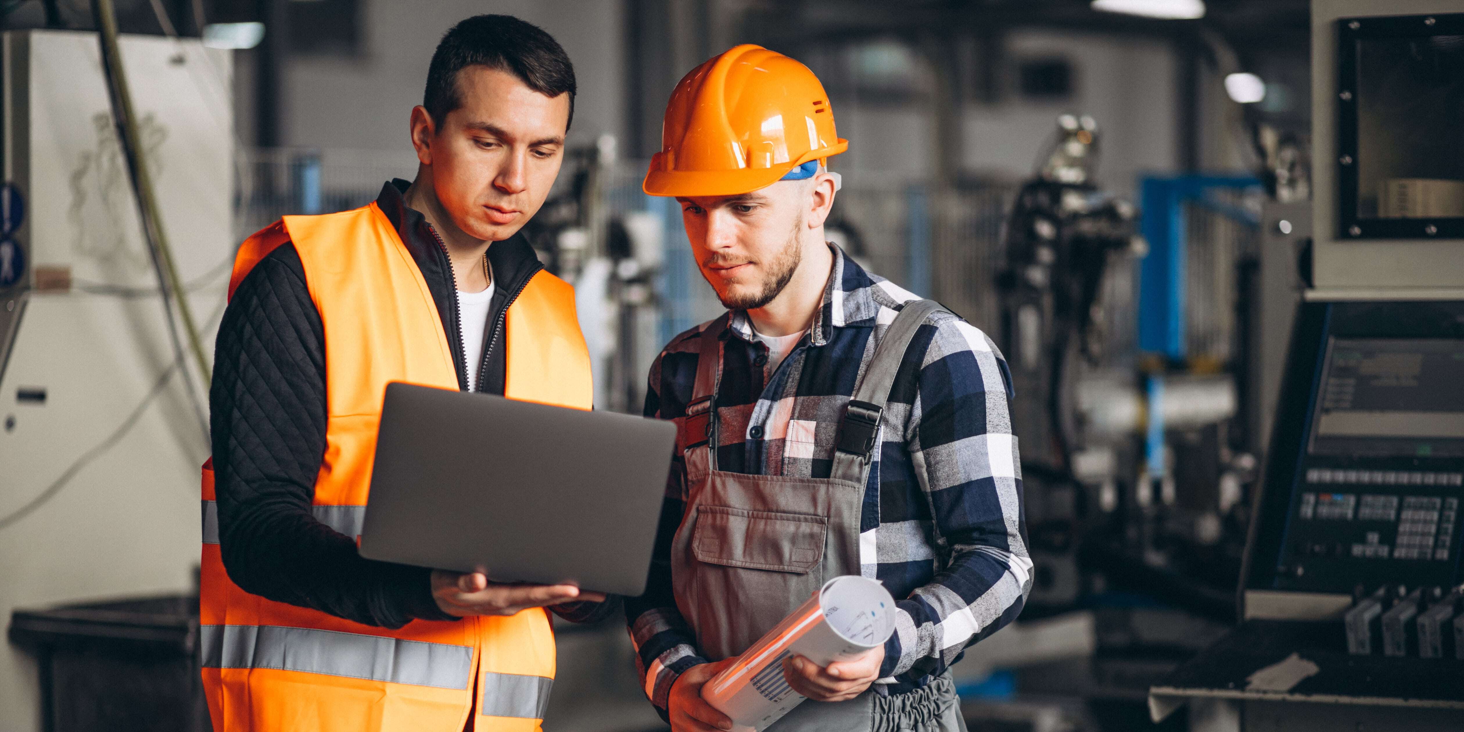 Deux techniciens qui analysent leur plan de maintenance preventive avec la GMAO